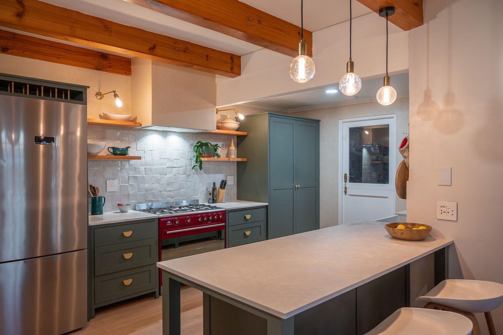 Kitchen with a red stove under timber beams