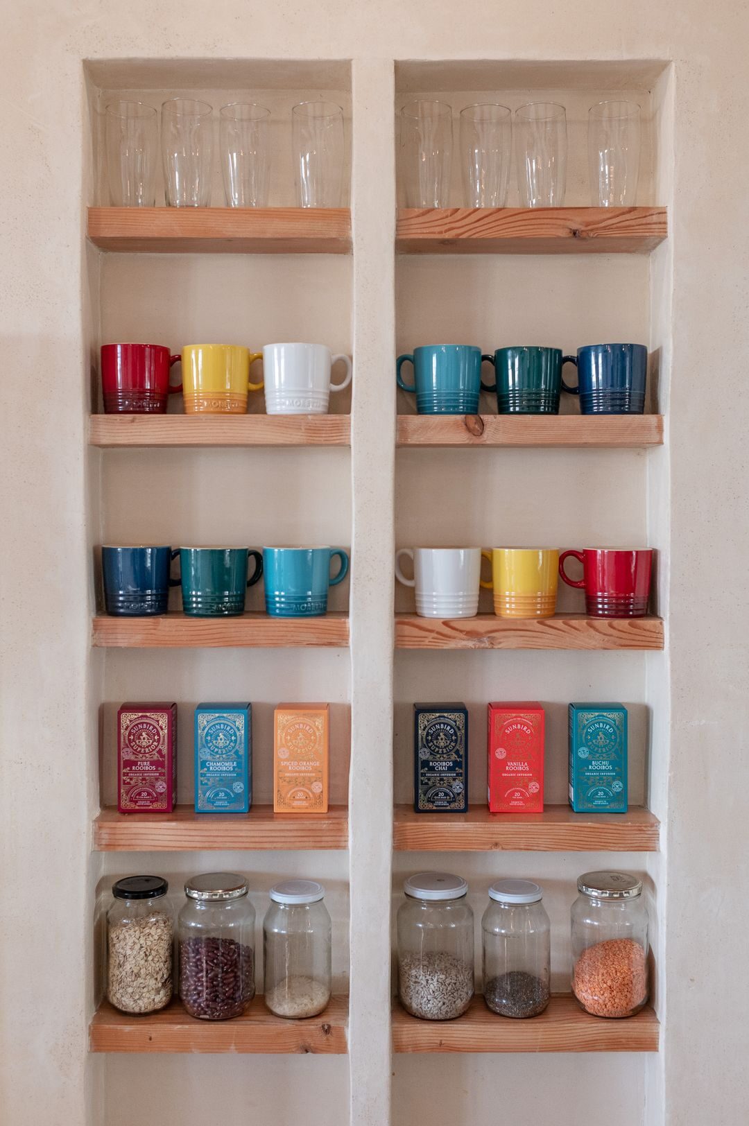 Open shelves of colourful mugs and glass jars